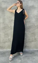 Vestido largo negro de corte recto, con escote en V y tirantes con lazos.