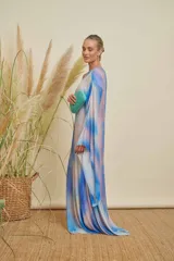 Vestido largo de tul con diseño degradado en tonos azul y rosado, de corte túnica con una sola manga larga acampanada y escote asimétrico. Incluye forro interior.