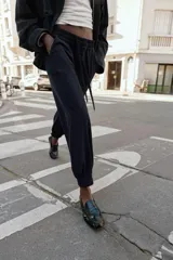 Pantalón jogger de tiro medio, color bordó, con cintura elástica ajustable mediante cordones, bolsillos delanteros y puños elásticos en los tobillos.