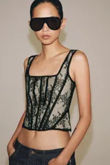 Corset confeccionado en poliamida con diseño de encaje floral y varillas estructuradas visibles. Presenta escote recto, tirantes anchos y forro interior en tono contrastante.
