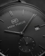 Reloj analógico de pulsera con caja redonda de metal negro, esfera minimalista con indicadores de hora, ventana de fecha y subesfera de segundos. Cuenta con correa de cuero negro y cierre de hebilla.