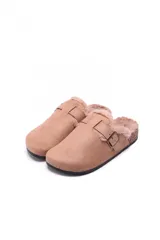 Sueco tipo zueco color beige, confeccionado en material gamuzado con interior forrado en piel sintética. Presenta una tira ajustable con hebilla metálica en el empeine y suela de corcho con base de goma antideslizante.