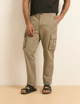 Pantalón cargo color verde militar, de corte recto, con bolsillos laterales con fuelle, bolsillos delanteros inclinados y bolsillos traseros.