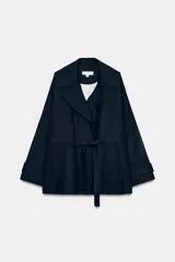 Chaqueta trench azul marino confeccionada con lino, con cuello de solapa, manga larga con trabillas en los puños, bolsillos delanteros de vivo y cierre frontal cruzado con cinturón de lazada.
