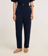 Pantalón zanahoria color fucsia de tiro alto, confeccionado en tejido airflow, con cintura elastizada, trabillas y hebillas metálicas.