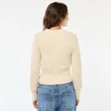 Sweater de punto fantasía en color beige, con cuello redondo y mangas largas. Presenta una textura suave y esponjosa, con un ajuste al cuerpo y puños acanalados.