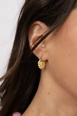 Aro de acero quirúrgico pequeño, recubierto con pequeñas mostacillas de color amarillo.
