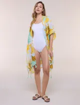 Kimono de gasa ligera con estampado floral en tonos amarillos, celestes, blancos y marrones, de manga corta amplia y diseño abierto con detalle de borlas en el ruedo asimétrico.