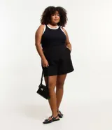 Musculosa negra de ribana con cuello redondo y sisas con ribete blanco en contraste.
