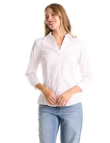 Camisa blanca de algodón con cuello camisero y escote en V. Presenta detalles plisados en el frente, cierre central con botones y mangas tres cuartos con puños abotonados. Los laterales están confeccionados en tejido modal para mayor comodidad.