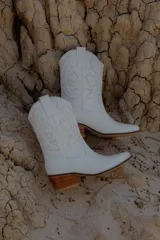 Botas blancas de cuero con bordados decorativos, punta texana y taco de 4 cm.