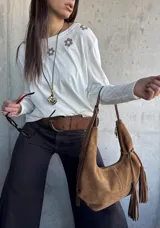 Remera blanca de manga larga con detalles bordados de flores en marrón en la parte superior frontal.