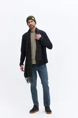 Camisa de manga larga color azul marino, confeccionada en algodón con textura, cuenta con un bolsillo frontal y cierre frontal con botones.