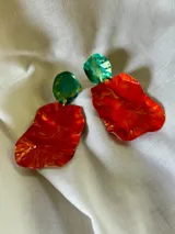Aros colgantes con forma irregular, con pieza superior redonda color verde y pieza inferior con diseño abstracto en tonos rojo, naranja y dorado.