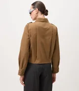 Campera corta y liviana de color marrón, con cuello clásico, cierre frontal con botones y mangas largas con puños ajustables.