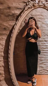 Vestido negro con escote halter y diseño cut-out en la cintura.