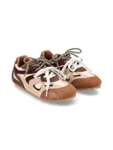 Sneaker urbano confeccionado en mix de cueros y texturas en tonos marrón, beige y bordó, con cordones combinados y suela dentada de goma.