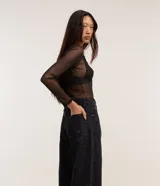 Pantalón baggy de corte holgado y tiro alto, confeccionado en sarga de algodón con estampado animal print de leopardo en tonos oscuros. Cuenta con trabillas en la cintura, cierre frontal con botón y cremallera, y bolsillos en la parte delantera y trasera.