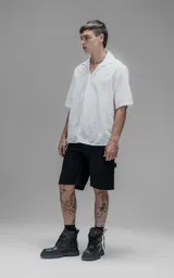 Camisa oversize blanca de manga corta y cuello abierto, confeccionada en algodón con diseño bordado.