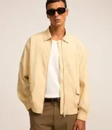 Campera masculina de ana ruga texturizada en color beige, con cuello inglés, cierre frontal por cremallera, bolsillos frontales con solapa, puños y cintura elásticos.