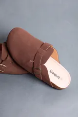 Sandalias estilo zueco de hombre, color marrón, con capellada cerrada, tira con hebilla ajustable lateral y suela de corcho y goma.