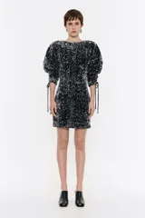 Vestido corto negro con lentejuelas plateadas, mangas abullonadas 3/4 con lazos ajustables y corte recto.