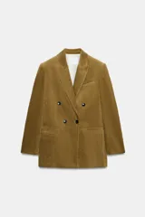 Blazer oversize de pana con cuello solapa y manga larga. Presenta cierre frontal cruzado con botones, bolsillos delanteros y forro interior a tono.