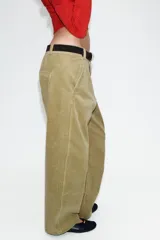 Pantalón de tiro alto confeccionado en pana, con diseño de pernera holgada que se estrecha hacia el tobillo. Presenta bolsillos delanteros, bolsillos de plastrón en la parte trasera, costuras marcadas en el frente y cierre frontal con cremallera y botón.
