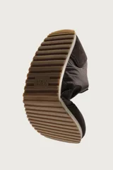 Zapatilla deportiva estilo barefoot, color marrón, con diseño de paneles en combinación de materiales y detalles en serraje. Cuenta con puntera redondeada y ancha, cordones en color crema y suela fina de goma flexible en contraste.
