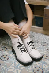 Mocasines color nude de charol con cordones negros y suela track color negro.