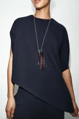 Capa de tejido de punto elástico con cuello redondo, manga corta y bajo asimétrico.