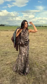 Falda larga de satén con estampado abstracto en tonos tierra, presenta un tajo frontal y detalles de envidado en lino a contratono. Cuenta con cierre lateral y forro interior.