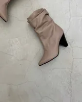 Botines dorados de cuero vacuno con punta fina y tacón aguja.