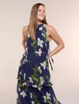Vestido maxi Julia Jordan de gasa estampada azul con flores blancas y hojas verdes, escote halter y diseño estructurado en paneles volados.