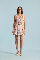 Vestido corto de color rosado con escote en V y sin mangas, confeccionado con un estampado floral detallado y simétrico de inspiración romántica.