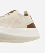 Championes casuales de knit en color beige con suela blanca y detalles en cuero sintético marrón en el talón y la lengüeta.
