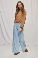 Jean wide leg blanco de tiro medio, con calce amplio y detalle de flores bordadas en los laterales.