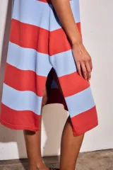 Vestido midi de tejido de punto con diseño de rayas horizontales anchas en color rojo y celeste. Presenta cuello redondo, mangas cortas y un corte recto y fluido.