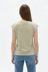 Remera de algodón color azul, de corte holgado, cuello redondo y mangas cortas con vuelta.