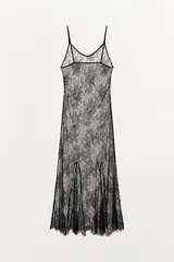 Vestido largo semitransparente confeccionado en encaje suave, con escote redondo, tirantes finos ajustables y bajo con acabado en ondas.