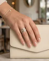 Anillo ancho de acero con baño de oro, compuesto por múltiples bandas texturizadas y una banda central engastada con circonias brillantes.