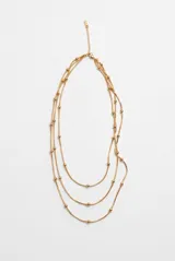 Collar tipo rosario de tres hilos en color dorado, con cadenas finas y pequeñas cuentas esféricas intercaladas a lo largo de las tiras.
