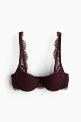 Soutien push-up con aros y copas con relleno, confeccionado en encaje color vino tinto. Presenta bordes festoneados en las copas y en la base, y tirantes anchos con borde festoneado.