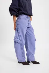 Jean de corte baggy con pierna ancha y recta, confeccionado en denim de tono azulado con efecto lavado. Presenta bolsillos cargo laterales, costuras reforzadas y detalle de bordado en la parte trasera.