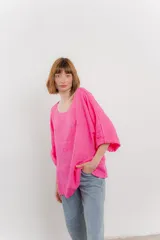 Blusa de lino color fucsia, con escote redondo y mangas 3/4 con puños doblados. Presenta un calce amplio y relajado.