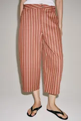 Jeans Zara Woman Collection de tiro alto y corte tapered, con diseño de rayas verticales a contraste en color marrón y beige. Presenta cinco bolsillos, trabillas para cinto y cierre frontal con cremallera y botón.