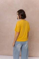 Remera negra de corte oversize con cuello redondo, mangas cortas amplias, hombros caídos y recortes delanteros.