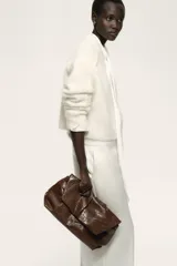 Pantalón de vestir blanco con cintura clásica, cierre con botón oculto y corchete. Presenta bolsillos al bies, bolsillo trasero decorativo y piernas amplias con pliegues marcados adelante y atrás.