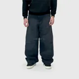 Jean de corte ultra baggy, color negro lavado, con diseño de paneles horizontales en las piernas y costuras reforzadas.