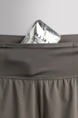 Short deportivo de trail running confeccionado en tejido técnico elástico con textura. Presenta una cintura elástica ancha con compartimentos integrados, bolsillo trasero con cierre y aberturas laterales en el bajo.